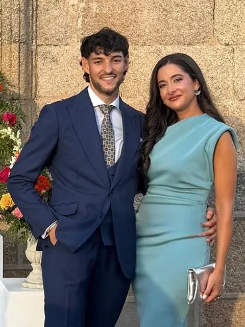 Álvaro y su pareja, sonriendo, de invitados en una boda
